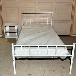 Set of White metal twin-size platform bed frame featuring an industrial spindle-style headboard and footboard. Night table and Mattress included.