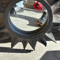 This is a sunburst wall mirror with a dark-toned, possibly bronze or black metal frame