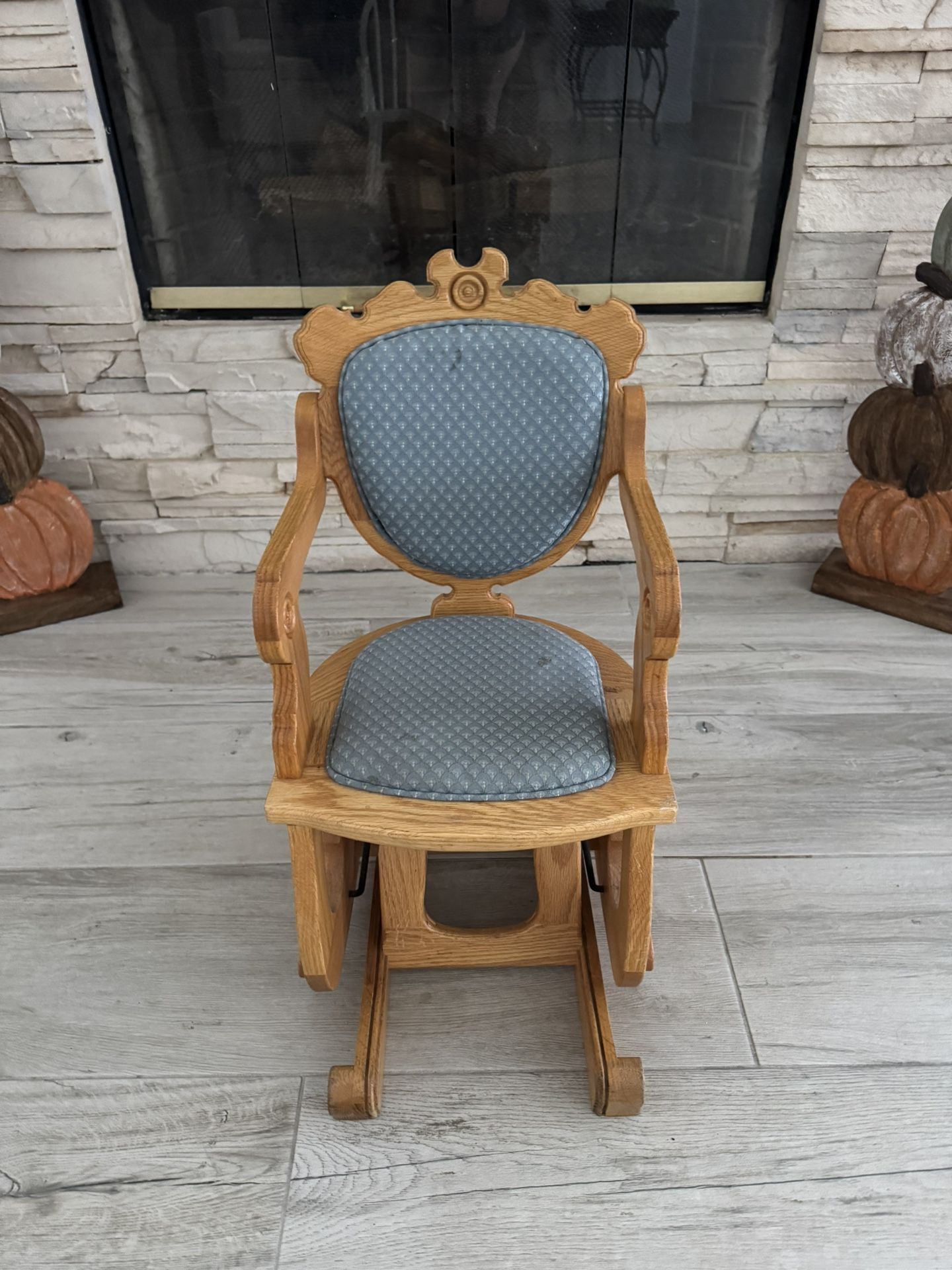 This is a vintage wooden rocking chair with a blue cushion