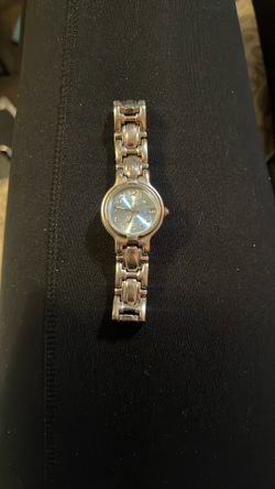 This is a vintage LA Express women's wristwatch with a silver-tone stainless steel band and a blue sunburst dial
