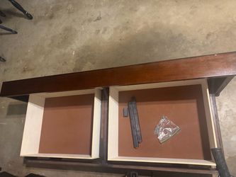 A dark brown queen size wooden bed base with two whole drawers