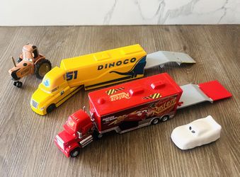 Disney/Pixar Cars hauler toy trucks. The yellow hauler belongs to Cruz Ramirez, and the red one is Mack, the transporter for Lightning McQueen