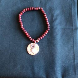 8 inch Dark Brown Stone Bracelet with a Rose Charm. (Back of Charm reads GROWTH).