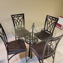  glass table with leather and metal chairs