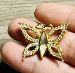 Delicate butterfly brooch in shimmering gold with clear crystal accents. Adds refined sparkle to jackets, scarves, and dresses. Lightweight and easy t