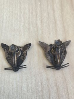 AI Overview



+4
The image shows a vintage screw-back earrings, likely featuring a cat