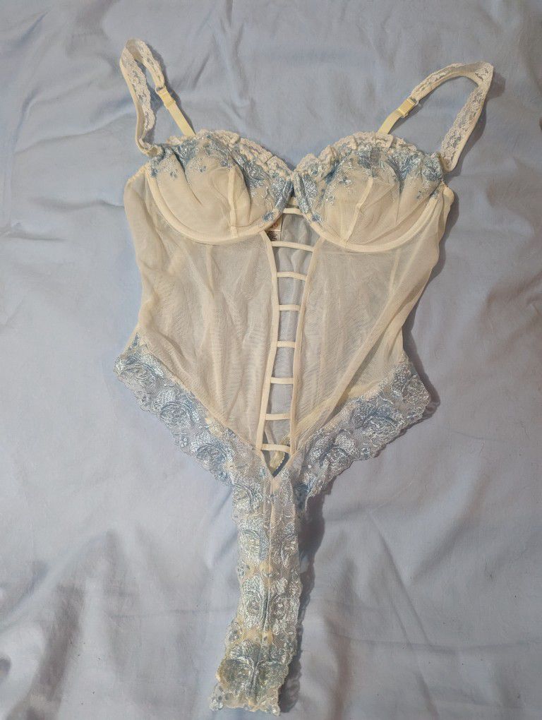 
Victoria Secret pale blue and white/cream Teddy Size: 36 C  adjustable shoulder straps Crotch area has snap closure See-through lace on the front and