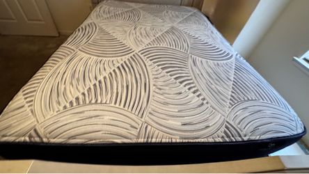 Comfortable Serta queen-sized mattress comes with boxspring a white and grey patterned top and dark blue sides. This mattress has a quilted surface wi