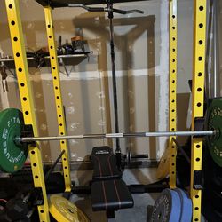 Squat rack with pulley system bumper plates and steel plates and bench