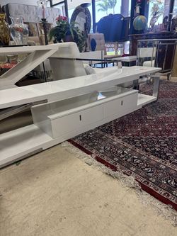 modern white high-gloss TV stand or entertainment console featuring drawers for storage -