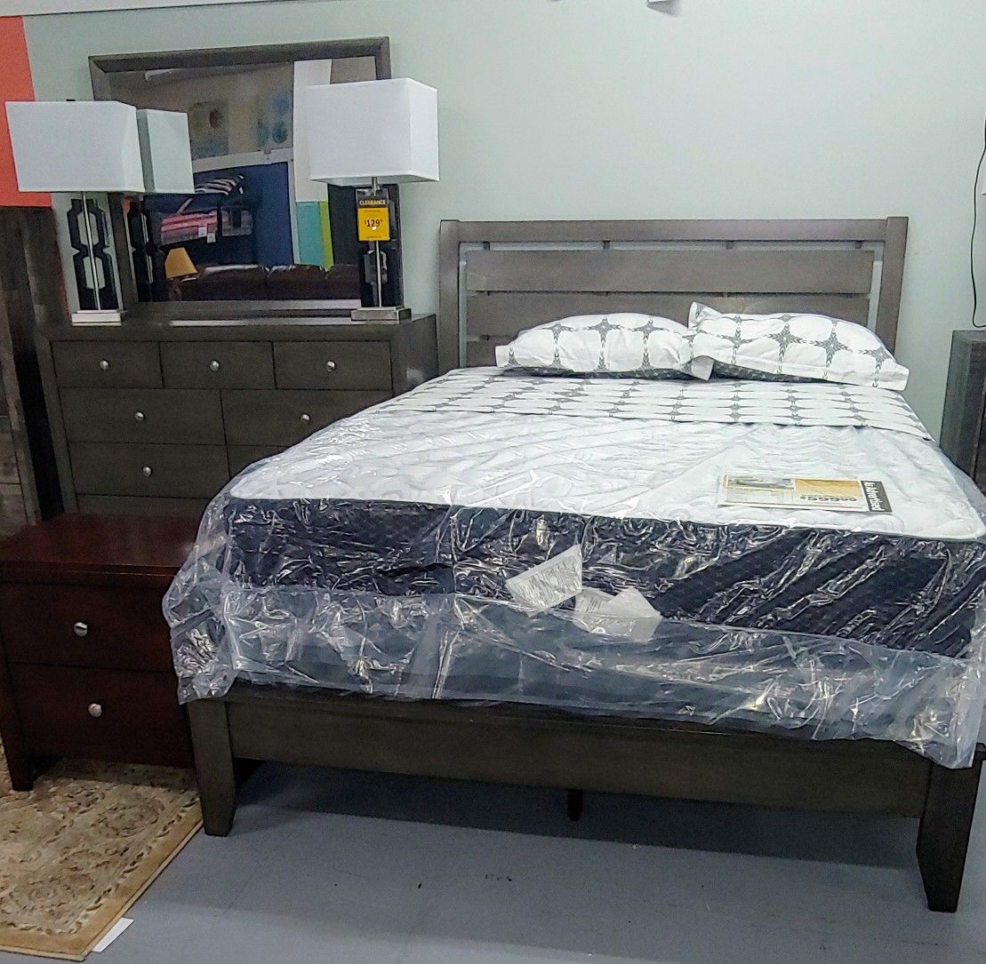 Gray Queen bed with dresser and mirror.