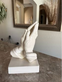 Beautiful praying‑hands sculpture