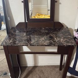 Dark brown vanity with a marble pattern.