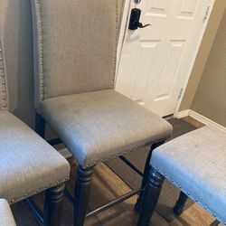 3 gray chairs and a bench