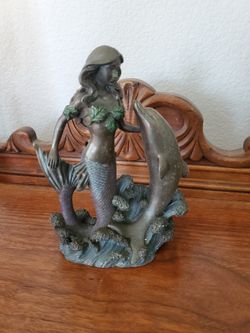 Collectible statue featuring a mermaid with a dolphin
