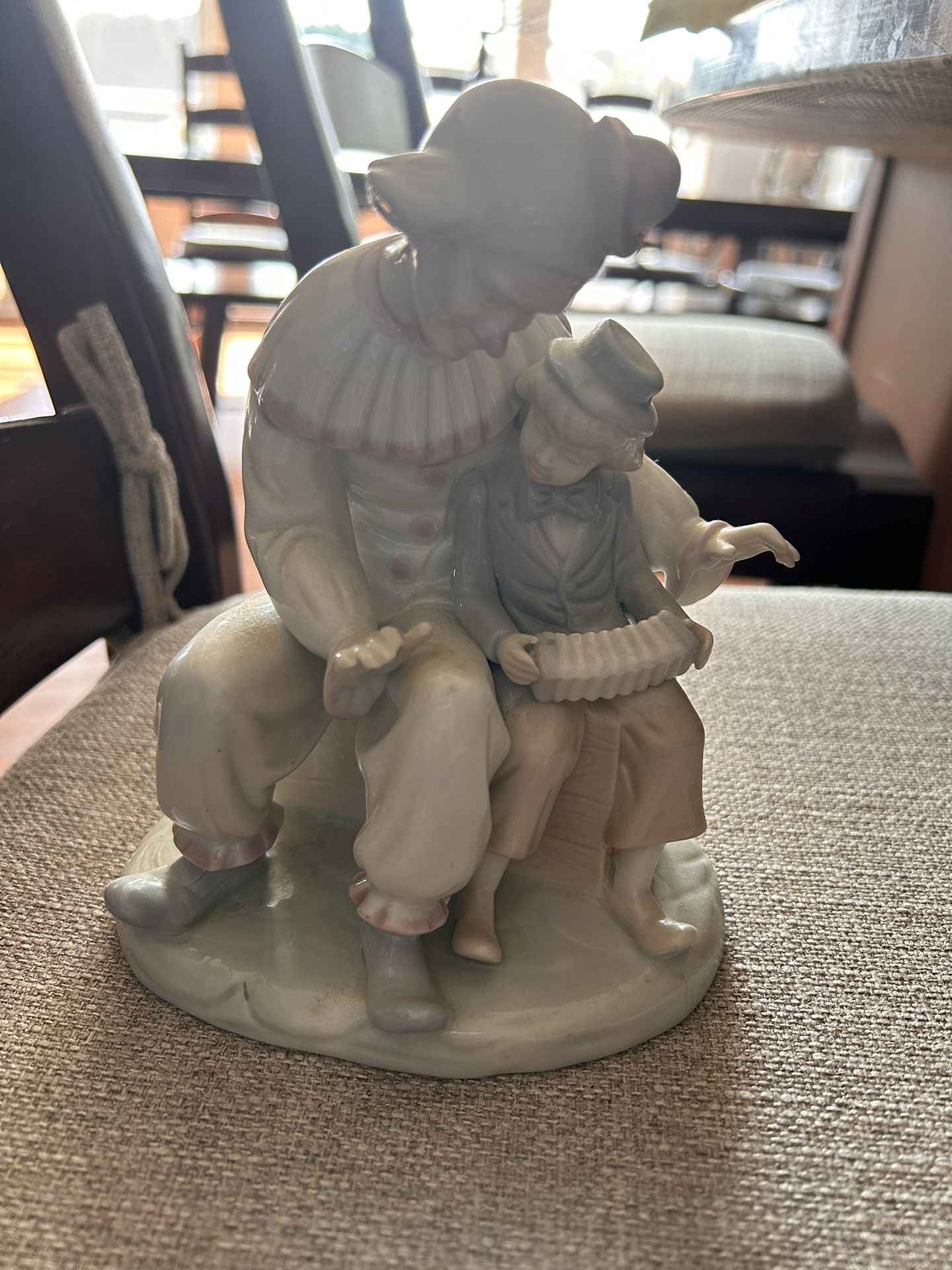 Clown encouraging a little boy to play the accordian.