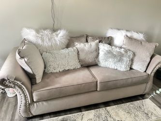 Grey sofa and loveseat with silver hardware. Throw pillows included
