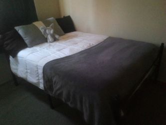 Queen mattress on a black metal frame