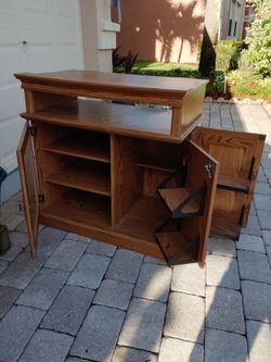 Classic oak color entertainment center. Open component 2 adjustable shelves. 2 fold out storage shelves behind door. Excellent condition. 34H 37W