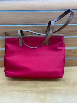 red Michael Kors Montauk nylon tote bag, featuring brown leather straps and gold-toned hardware.