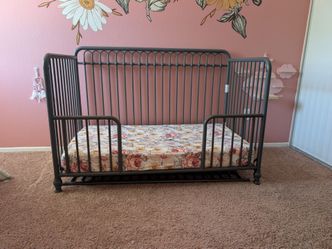 Grey metal crib and Newton Baby mattress