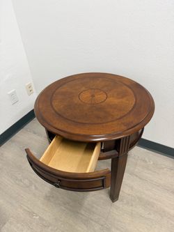 Circular brown end table with drawer