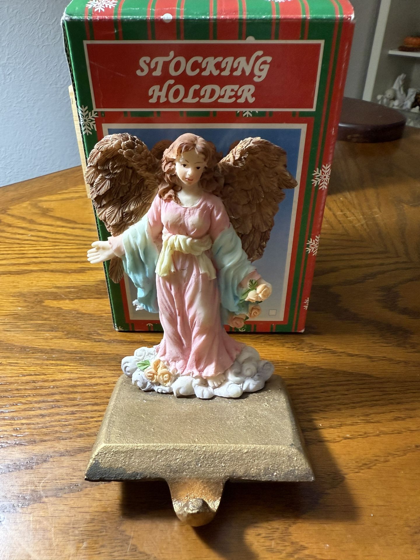 This is a hand-painted angel figurine that functions as a Christmas stocking holder.  