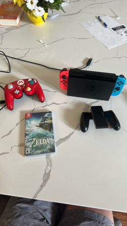 Nintendo switch with Legend of Zelda Tears of the kingdom, a switch pro controller, and wired game cube controller