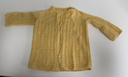 Yellow knitted baby or small child’s cardigan sweater.