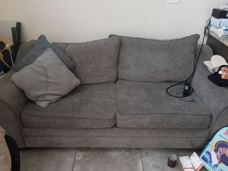 Grey 80 inch sofa with sleeper bed in it.