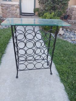 Wine  rack with glass top holds 20 bottles.