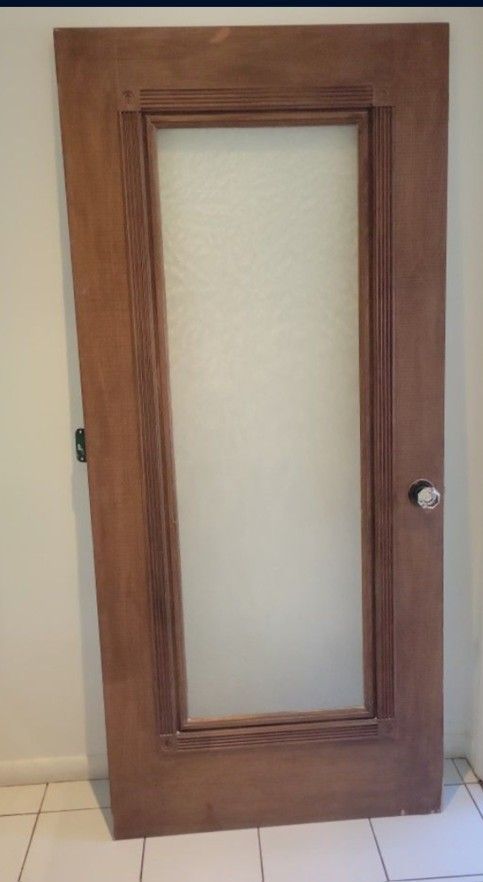 wooden interior door with a frosted or textured glass panel