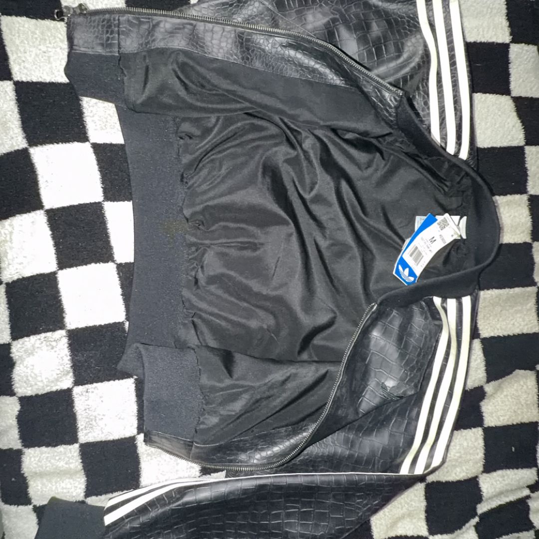 Adidas name brand Women’s black with white stripes, leather, genuine jacket. Yes, with the tags still attacked.