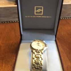 Men’s gold watch, has never been worn. Still in the box with extra links.