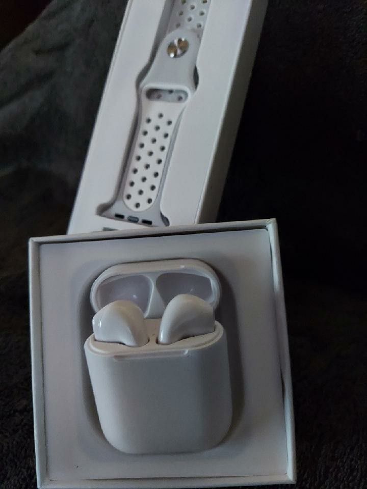White Bluetooth smart watch and white headphones