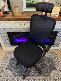 Black mesh, ergonomic office chair with headrest, flip arms, and collapsible back