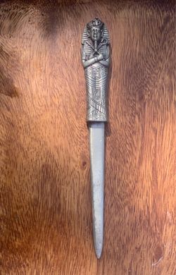 Vintage Egyptian Revival style letter opener, often featuring a design inspired by King Tutankhamun or other pharaohs.