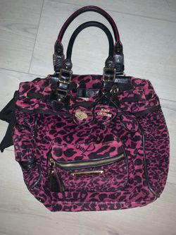 a Juicy Couture leopard print velour daydreamer bag featuring iconic heart charms and black handles.