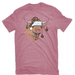 Pink t-shirt featuring a Highland cow graphic with festive ornaments.