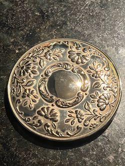 This is a vintage Princess House silverplated purse mirror featuring an ornate repousse floral design