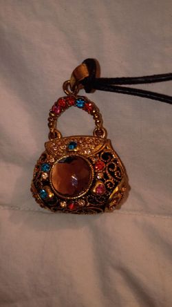 Rhinestone purse pendant on cord.