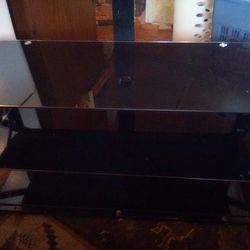 Black Glass Entertainment System With Three Shelves An Amount On Top For Flat Screen TVs