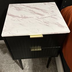 Two bedside tables. Black with white marble looking top. Two drawers.