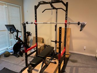 squat rack w/ pulley system; barbell; bumper plates; adjustable dumbell