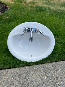 White oval bathroom sink and faucet