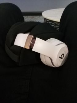 pair of white and rose-gold Beats Solo 4 Wireless Headphones in the Cloud Pink colorway.