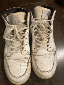 Worn Air Jordan 1 Mid ladies sneakers in a white and blue .
