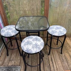 Bar height glass top table and three stools