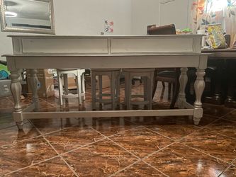 Behind the couch table and 3 chairs
