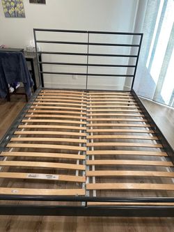 Queen-size metal bed frame with wooden slats.